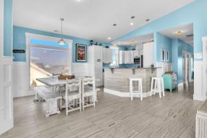 a kitchen with blue walls and a table and chairs at Conch Out by Oak Island Accommodations in Oak Island +77 photos
