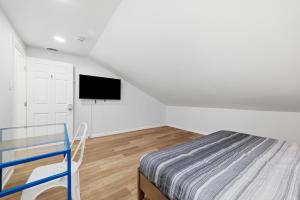 a bedroom with a bed and a flat screen tv at Pittsburgh Millvale E Modern and Quiet Private Bedroom with Shared Bathroom in Pittsburgh