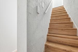 a staircase with wooden floors and a number on the wall at Pittsburgh Millvale E Modern and Quiet Private Bedroom with Shared Bathroom in Pittsburgh