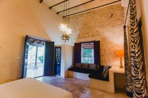 a living room with a couch and a window at Hacienda Sacnicte in Izamal +121 photos