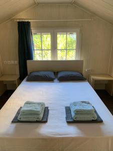 a bedroom with a large bed with towels on it at Nadia's Beach House in Pefkari