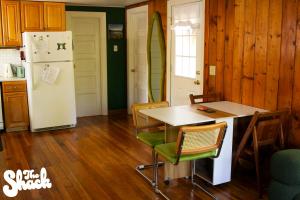a kitchen with a table and chairs and a refrigerator at The Shack at Long Beach - A Psychedelic Getaway in Long Beach