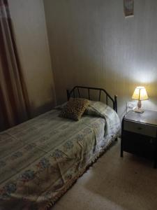 a bedroom with a bed and a lamp on a table at Amelia in San Juan