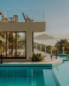 a house with a swimming pool with a view of the ocean at Pousada Caminho do Rei in Praia do Rosa