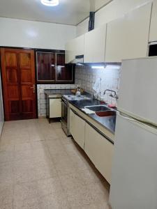 a kitchen with white cabinets and a sink at Amelia in San Juan