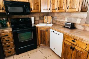 a kitchen with wooden cabinets and a black appliance at Desert Oasis Condo in Green Valley +16 photos