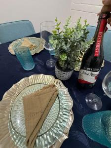 a table with a glass plate and a bottle of wine at Confortable estancia de 1 a 4 personas in Guamúchil