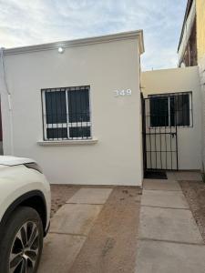 a white building with two windows on it at Confortable estancia de 1 a 4 personas in Guamúchil