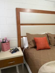a bedroom with a bed with a nightstand and a table with a box at Confortable estancia de 1 a 4 personas in Guamúchil +3 photos