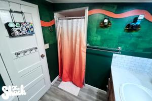 a bathroom with green walls and a shower at The Shack at Long Beach - A Psychedelic Getaway in Long Beach +7 photos