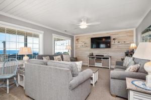 a living room with couches and a flat screen tv at Dip Inn by Oak Island Accommodations in Oak Island +68 photos