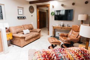 a living room with leather furniture and a flat screen tv at Calle Condo in Green Valley