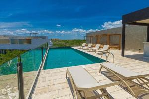 a swimming pool with lounge chairs on a patio at PH 3-Bedroom Private Pool in TUK in Tulum
