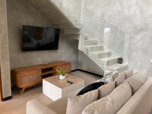 a living room with a couch and a tv and stairs at PH 3-Bedroom Private Pool in TUK in Tulum