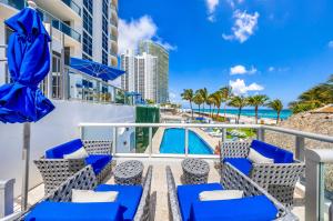 a balcony with blue chairs and the beach at Oceanview Apt Marenas Resort, Direct Beach Access! in Sunny Isles Beach