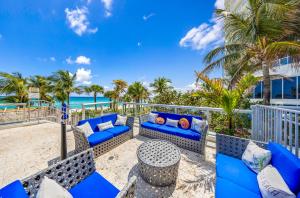 a patio with blue furniture and the beach at Oceanview Apt Marenas Resort, Direct Beach Access! in Sunny Isles Beach