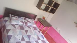 a bedroom with a bed with a quilt on it at Fure Wassi Hostel in Cabanaconde