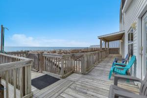 a deck with two blue chairs and the ocean at Divine Intervention by Oak Island Accommodations in Oak Island