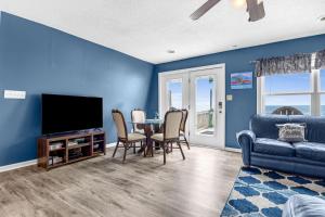 a living room with a tv and a table with chairs at Divine Intervention by Oak Island Accommodations in Oak Island +48 photos