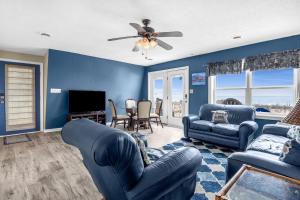 a living room with blue walls and a ceiling fan at Divine Intervention by Oak Island Accommodations in Oak Island