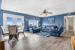 a living room with blue walls and a table and chairs at Divine Intervention by Oak Island Accommodations in Oak Island