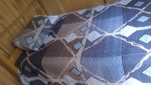 a bed with a quilt on top of it at Fure Wassi Hostel in Cabanaconde
