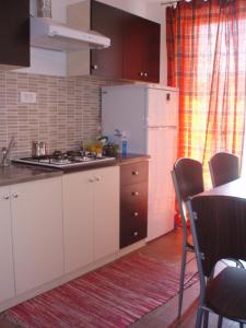 eine Küche mit Kühlschrank und einem Tisch mit Stühlen in der Unterkunft ABC Lešnik in Koper