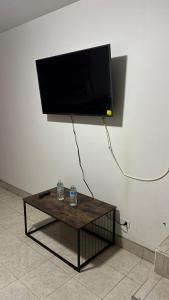 a flat screen tv hanging on a wall with a coffee table at Casa Vivanco apartment #5 in Ensenada
