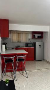 a kitchen with red cabinets and a table with two chairs at Casa Vivanco apartment #5 in Ensenada