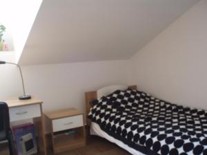ein Schlafzimmer mit einem schwarz-weißen Bett und einem Schreibtisch in der Unterkunft ABC Lešnik in Koper