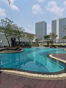 a large blue swimming pool with buildings in the background at Cozy 1BR UResidence 2 by REJA Essentials in Klapadua
