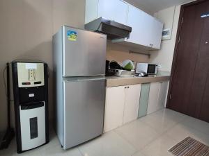 a small kitchen with a refrigerator and a microwave at Cozy 1BR UResidence 2 by REJA Essentials in Klapadua