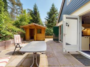 eine Terrasse mit Tisch und einem Schuppen in der Unterkunft Borre Bos in Diever