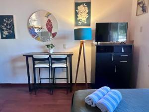 a bedroom with a bed and a table and a mirror at Le Colibri - 1 Min Beach - Pool - Serenity in La Peñita de Jaltemba