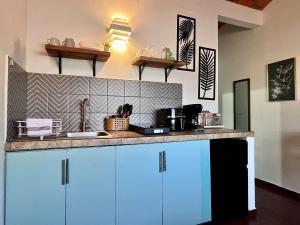 a kitchen with blue cabinets and a counter top at Le Colibri - 1 Min Beach - Pool - Serenity in La Peñita de Jaltemba