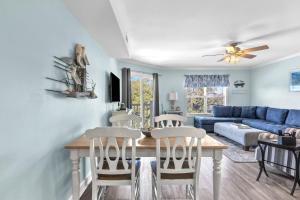 a living room with a table and chairs and a couch at Dolphy Daze by Oak Island Accommodations in Oak Island +35 photos