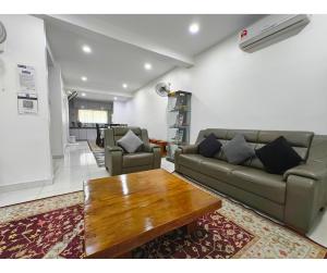 a living room with a couch and a coffee table at 61 StayAtHome in Nibung Tebal