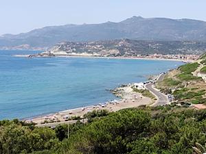 a beach with a bunch of umbrellas and the ocean at MAREVIGLIOSO Fronte Mare Sea Front in Magomadas