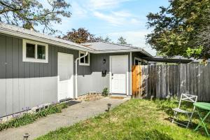 a gray house with a fence and a yard at Basecamp GP- Private Unit in Quiet Duplex Near Downtown in Grants Pass