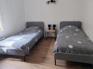 two beds sitting next to each other in a bedroom at La suite du beffroi in Malaucène