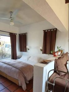 a bedroom with a large bed and a chair at Quita penas in Los Reartes