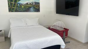 a bedroom with a bed and a flat screen tv at Apartamento duplex villa 19 de lujo in Armenia +14 photos
