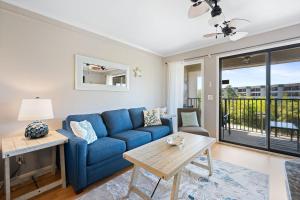 a living room with a blue couch and a table at New Listing - Spring Discounts Beach View Condo in Hilton Head Island