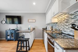 a kitchen with white cabinets and marble counter tops at New Listing - Spring Discounts Beach View Condo in Hilton Head Island