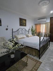 a bedroom with a bed and a table with flowers at Providence Guesthouse and Catering Services in Abidjan