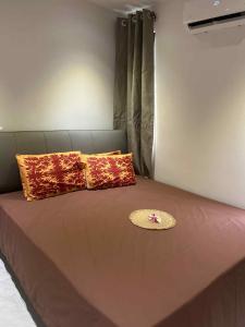 a brown bed with pillows and a hat on it at Matirina Ura lodge in Arue