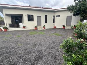 a white house with potted plants in front of it at Matirina Ura lodge in Arue