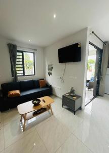 a living room with a black couch and a table at Matirina Ura lodge in Arue