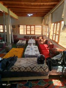 a large room with couches and tables in it at Auberge High Atlas B&B in Alemrhou