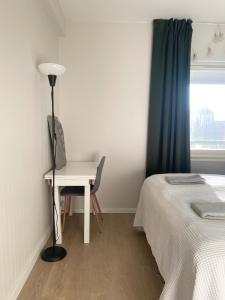 a bedroom with a desk and a bed and a lamp at Apartments Maaherrankatu in Kuopio